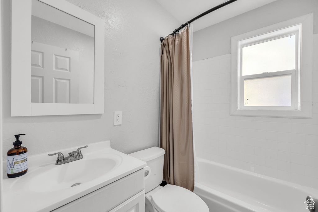 Full bathroom featuring vanity, shower / tub combo, and toilet