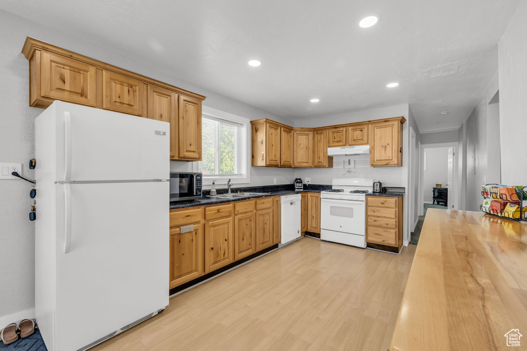 Kitchen featuring white appliances, light hardwood / wood-style flooring, and sink