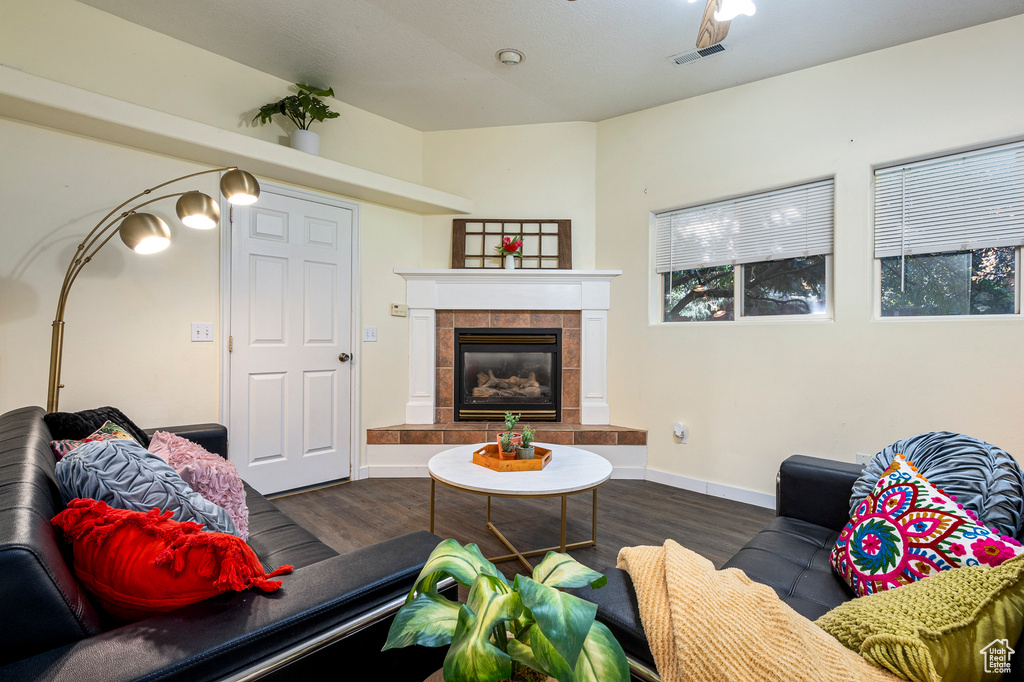 Living room with dark hardwood / wood-style floors and a tile fireplace