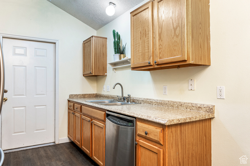 Kitchen with lofted ceiling, sink, a textured ceiling, dark wood-type flooring, and dishwasher