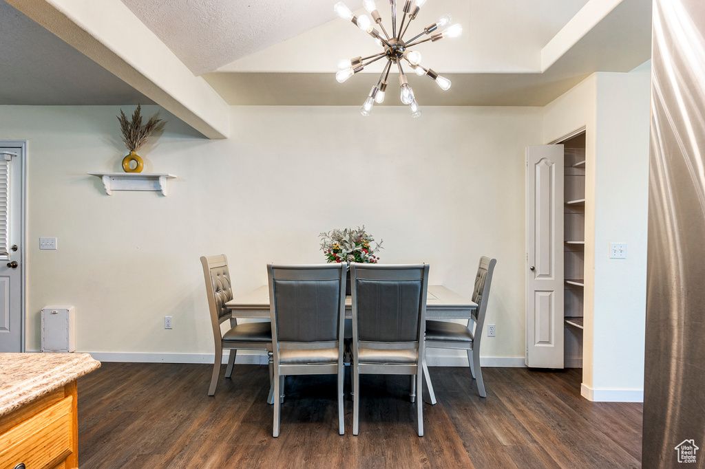 Dining space featuring an inviting chandelier, dark hardwood / wood-style floors, and a textured ceiling