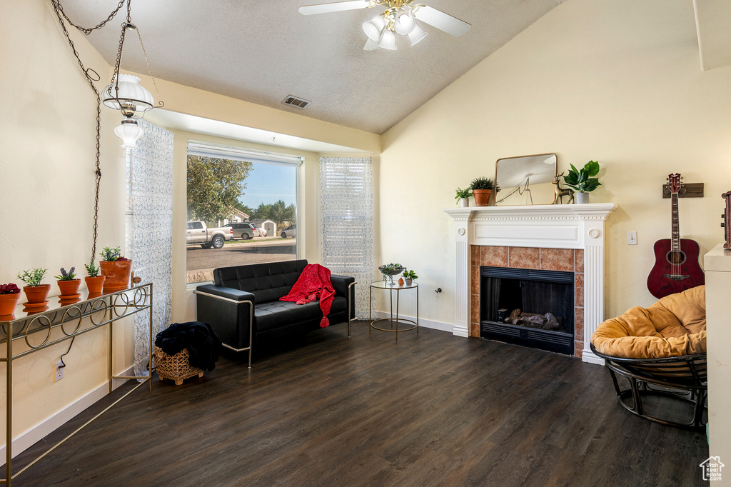 Living area featuring wood-type flooring, a fireplace, high vaulted ceiling, and ceiling fan