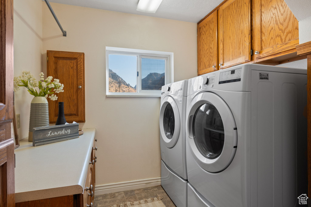 Laundry area with washer and clothes dryer and cabinets