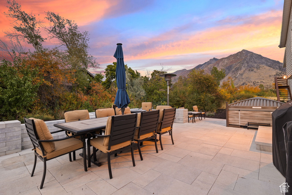 Patio terrace at dusk featuring a mountain view