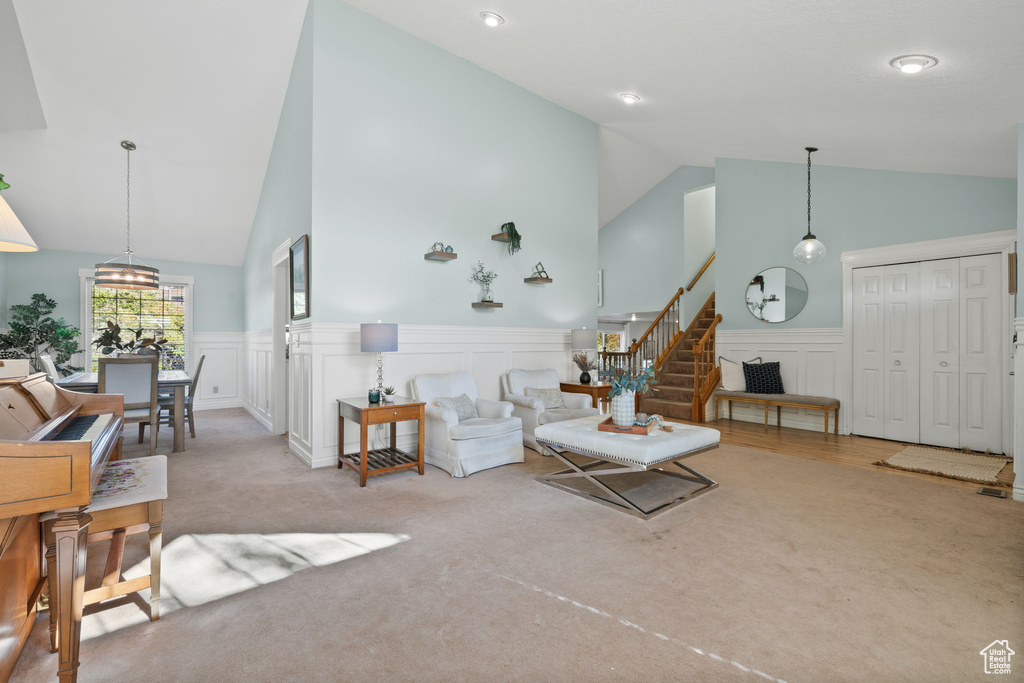 Carpeted living room featuring high vaulted ceiling