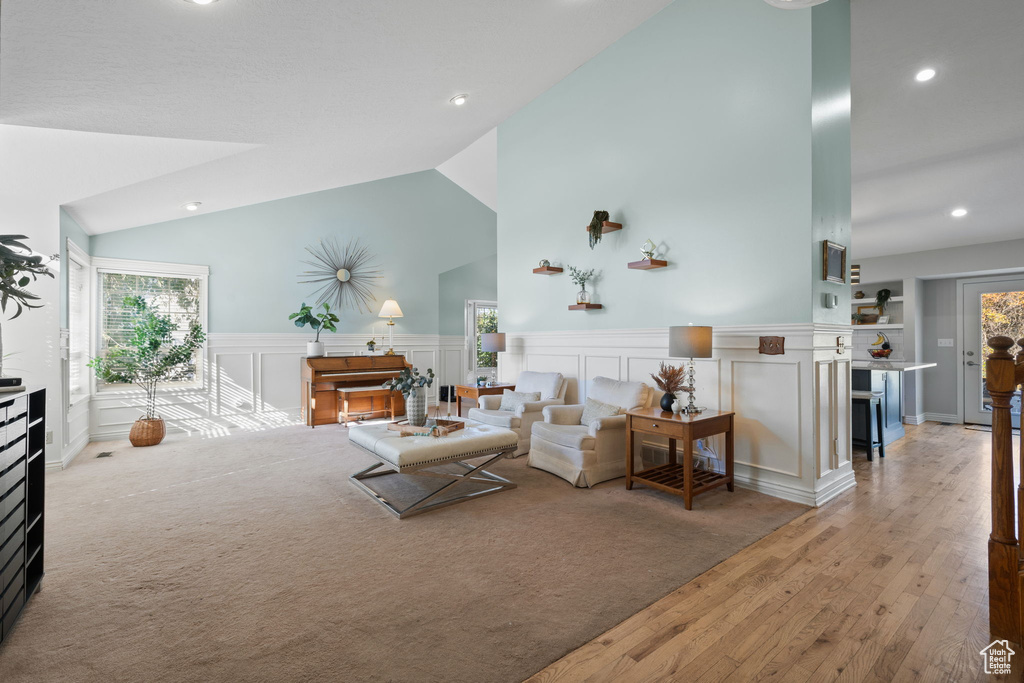 Living room with light hardwood / wood-style floors and high vaulted ceiling