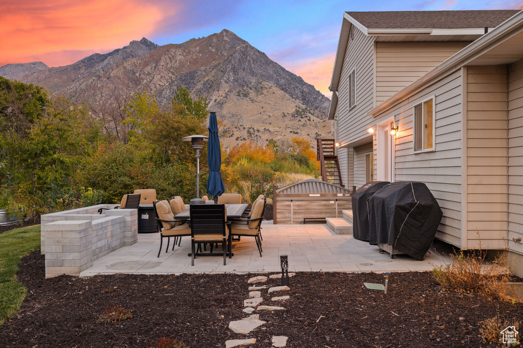 Patio terrace at dusk with a mountain view and a grill