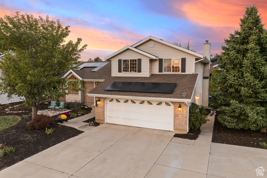 View of front of house with a garage and solar panels