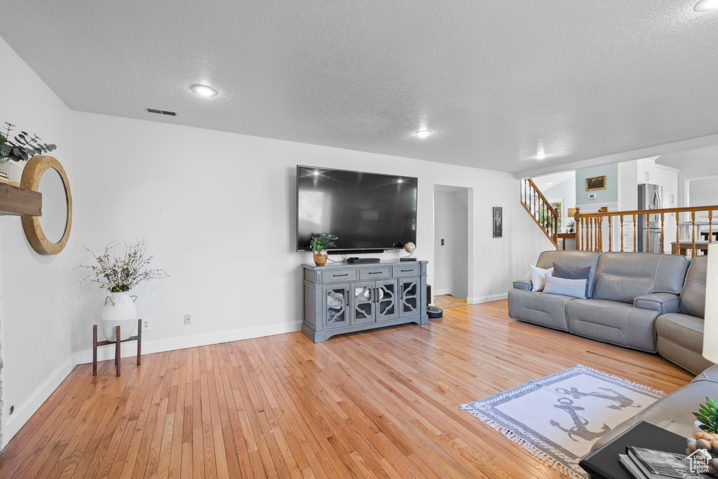 Living room with wood-type flooring and a textured ceiling