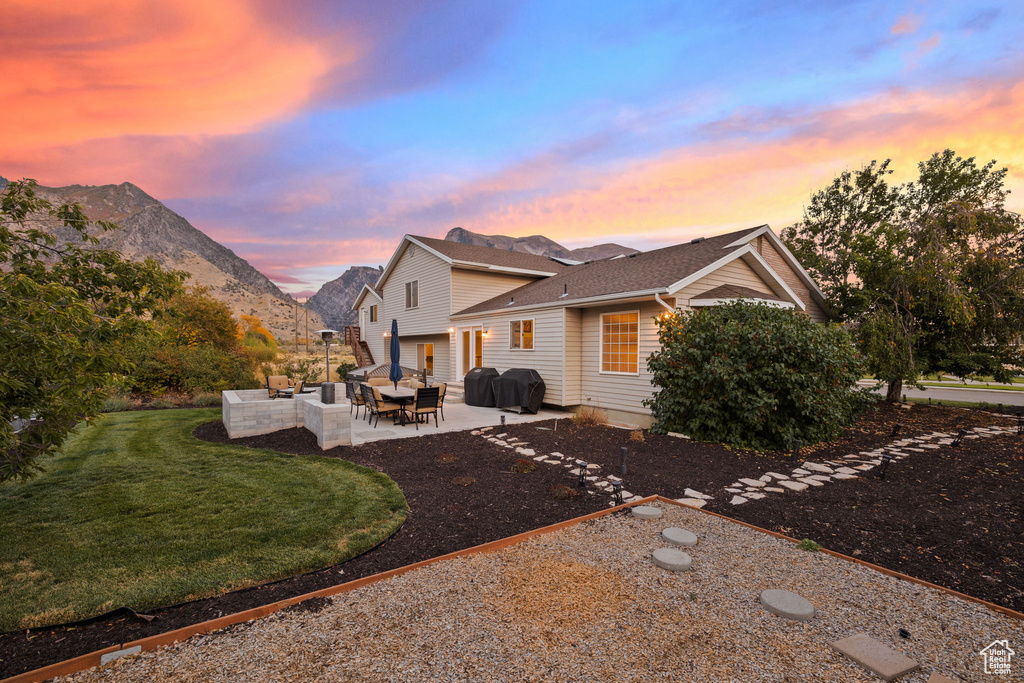 Exterior space with an outdoor living space, a mountain view, a lawn, and a patio area