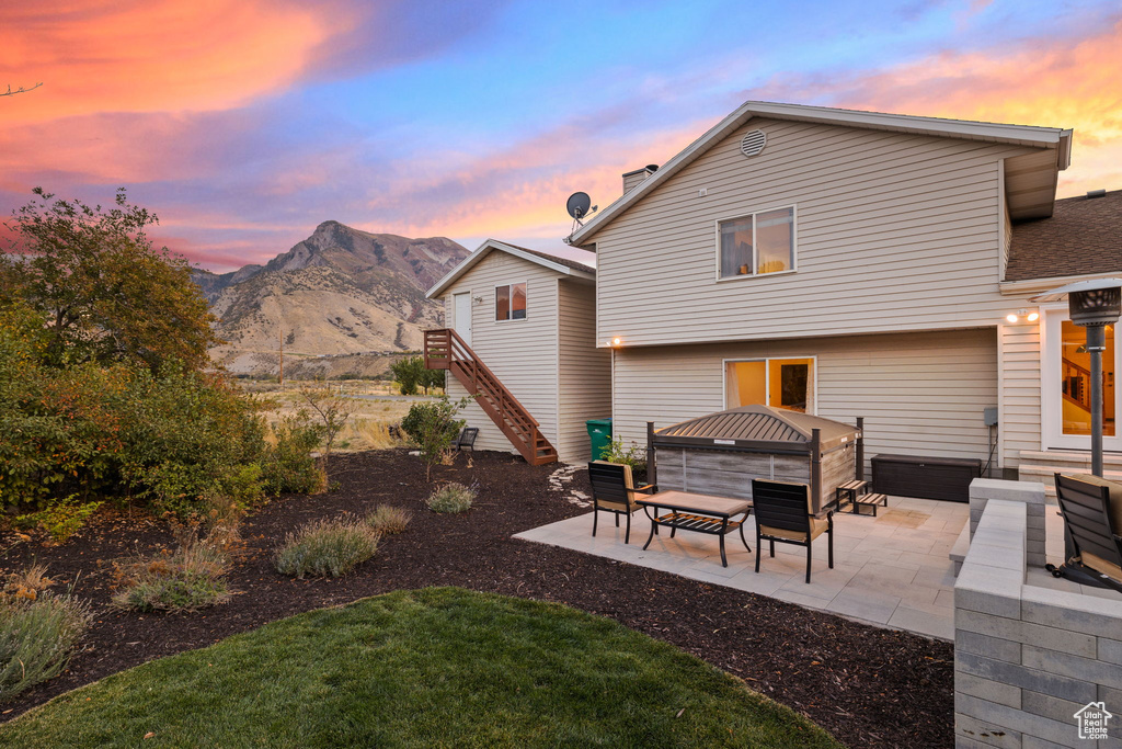 Back house at dusk with a patio and a mountain view