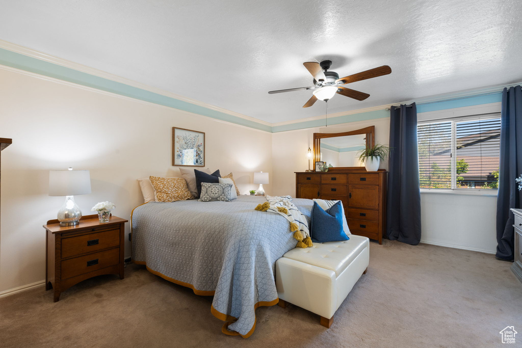 Carpeted bedroom featuring ornamental molding, ceiling fan, and a textured ceiling