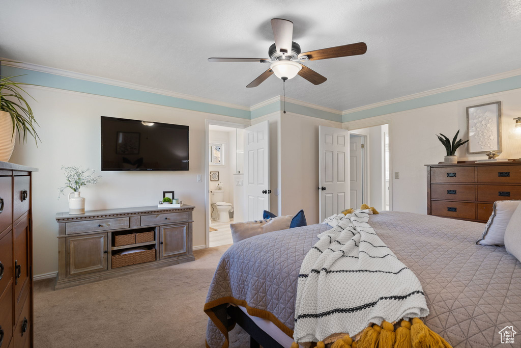 Bedroom with light carpet, ensuite bath, ornamental molding, and ceiling fan