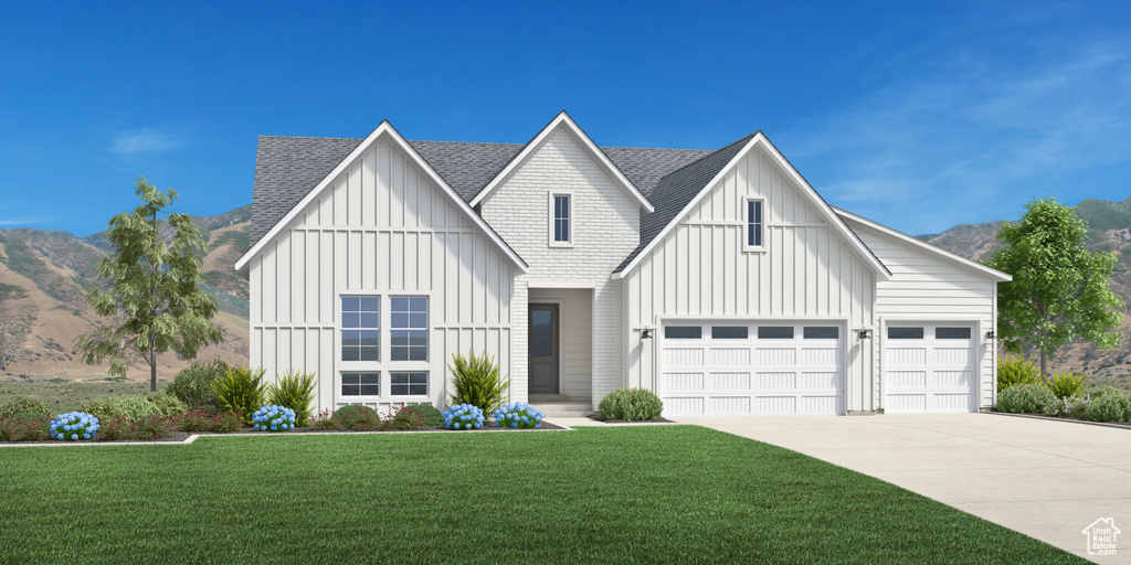 Modern inspired farmhouse with a mountain view, a front yard, and a garage