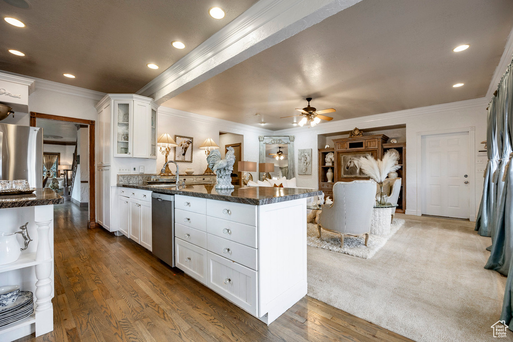 Kitchen featuring crown molding, a sink, a peninsula, stainless steel appliances, and white cabinetry