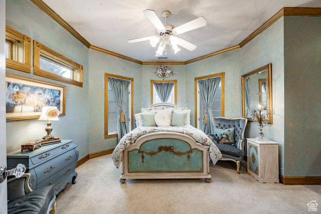 Bedroom featuring baseboards, a ceiling fan, crown molding, and light carpet