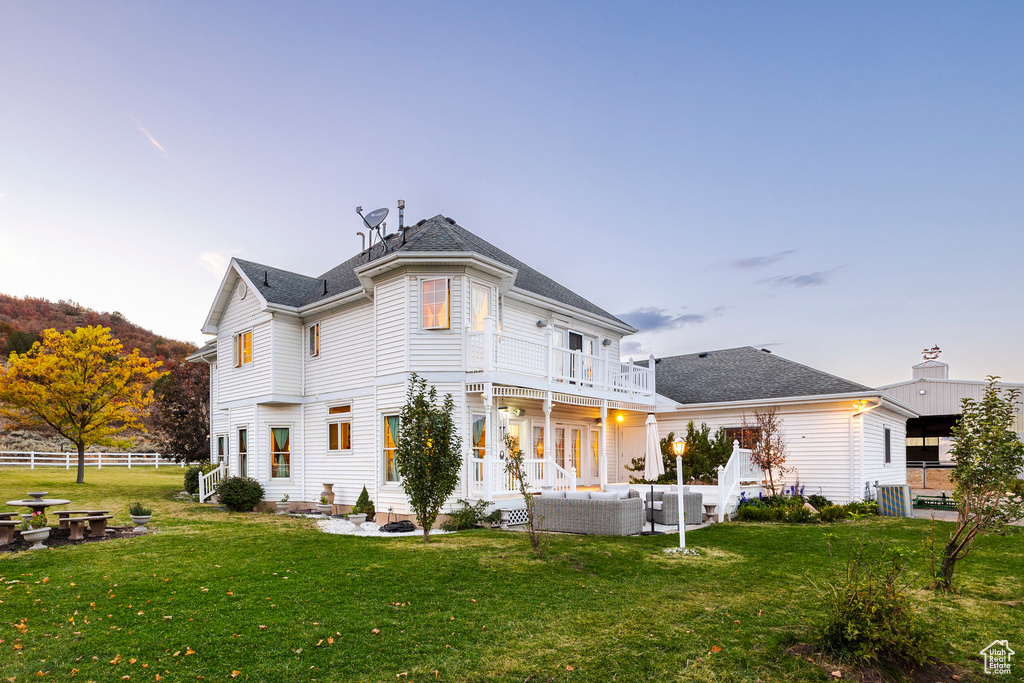 Back of property with an outdoor living space, fence, a balcony, a yard, and a patio