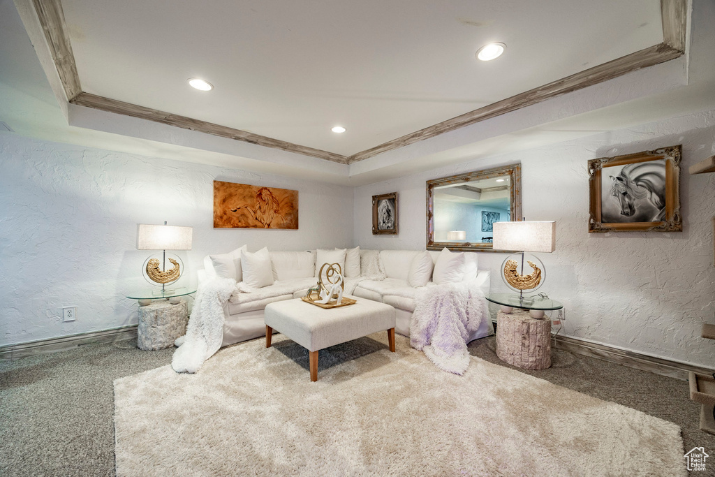 Carpeted living room featuring recessed lighting, a textured wall, crown molding, and baseboards