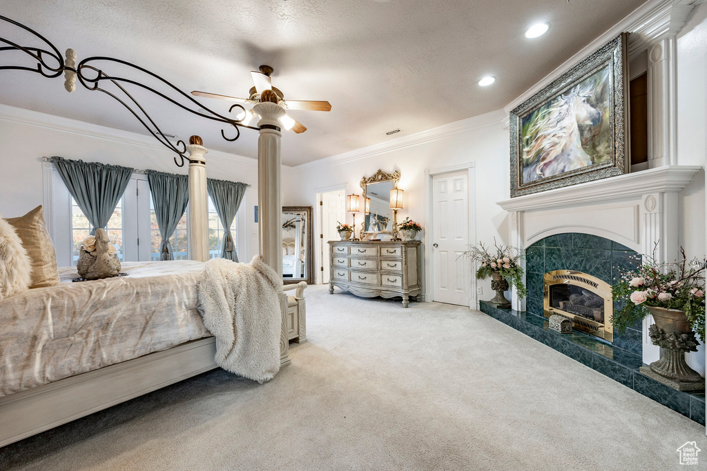 Carpeted bedroom with crown molding, recessed lighting, ceiling fan, and a high end fireplace