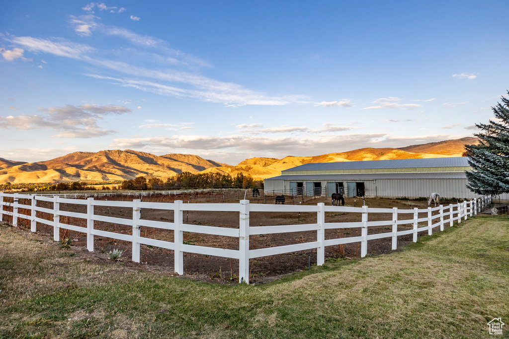 View of yard with fence, an outbuilding, and a mountain view