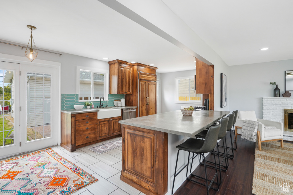 Kitchen featuring plenty of natural light, hanging light fixtures, sink, and tasteful backsplash