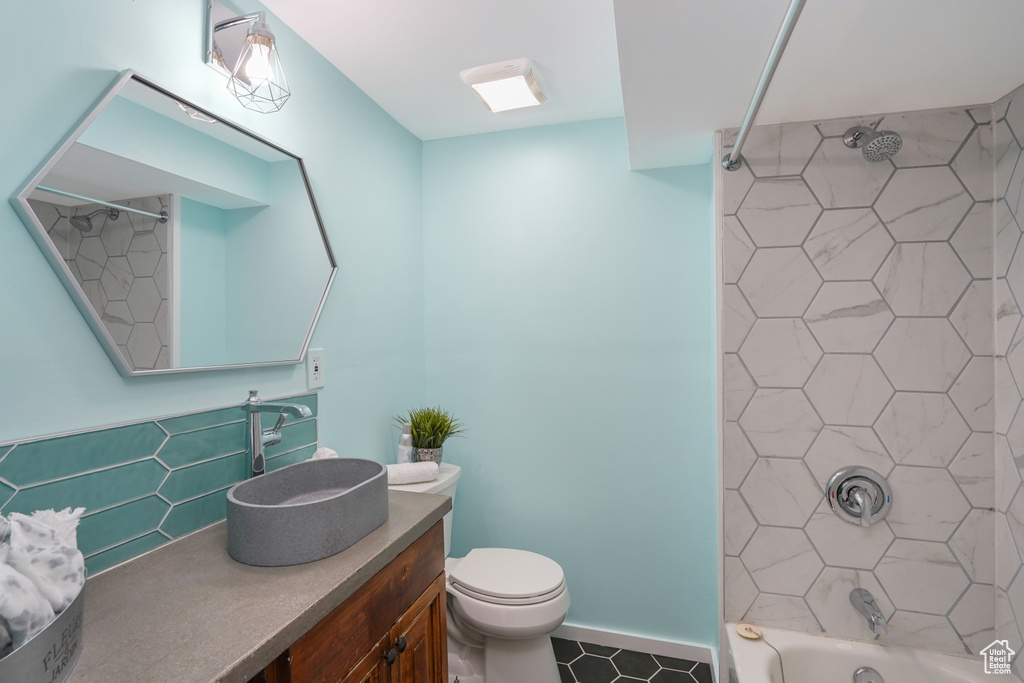 Full bathroom featuring toilet, vanity, and tiled shower / bath combo