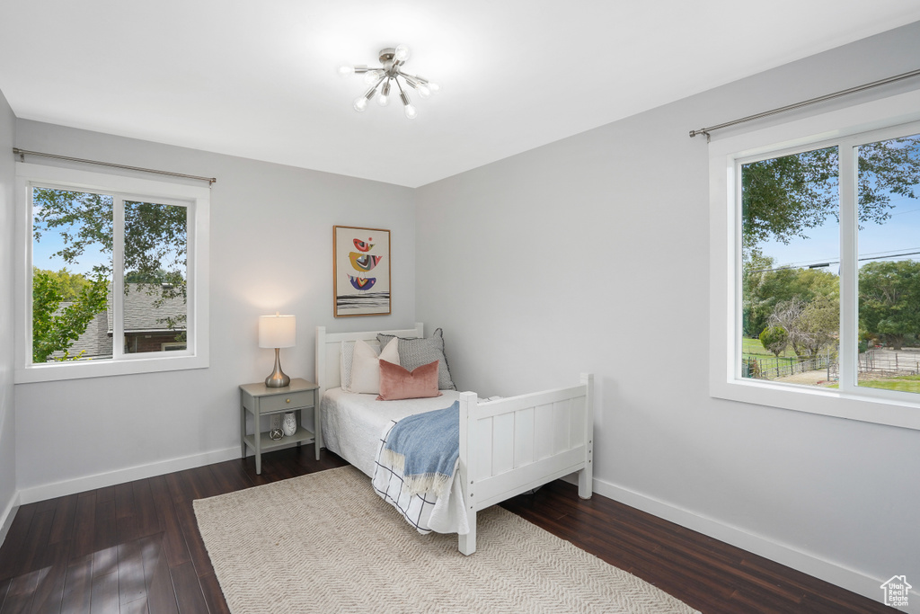 Bedroom with dark hardwood / wood-style flooring