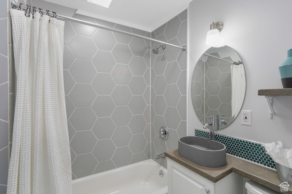 Bathroom featuring vanity and shower / bath combination with curtain