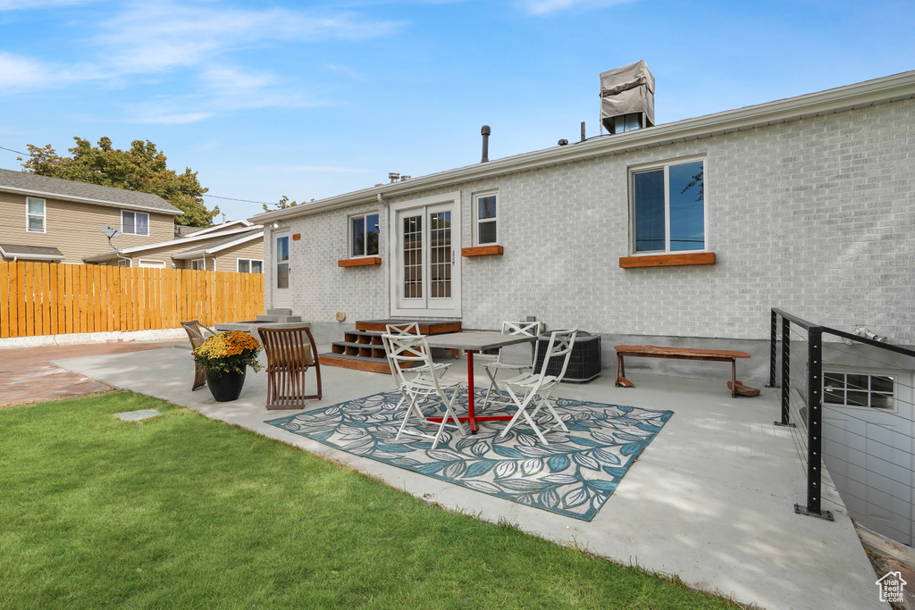 Rear view of house with french doors, a yard, a patio, and central air condition unit