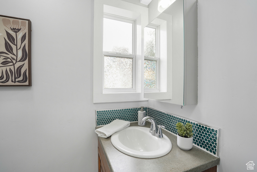 Bathroom featuring vanity and tasteful backsplash