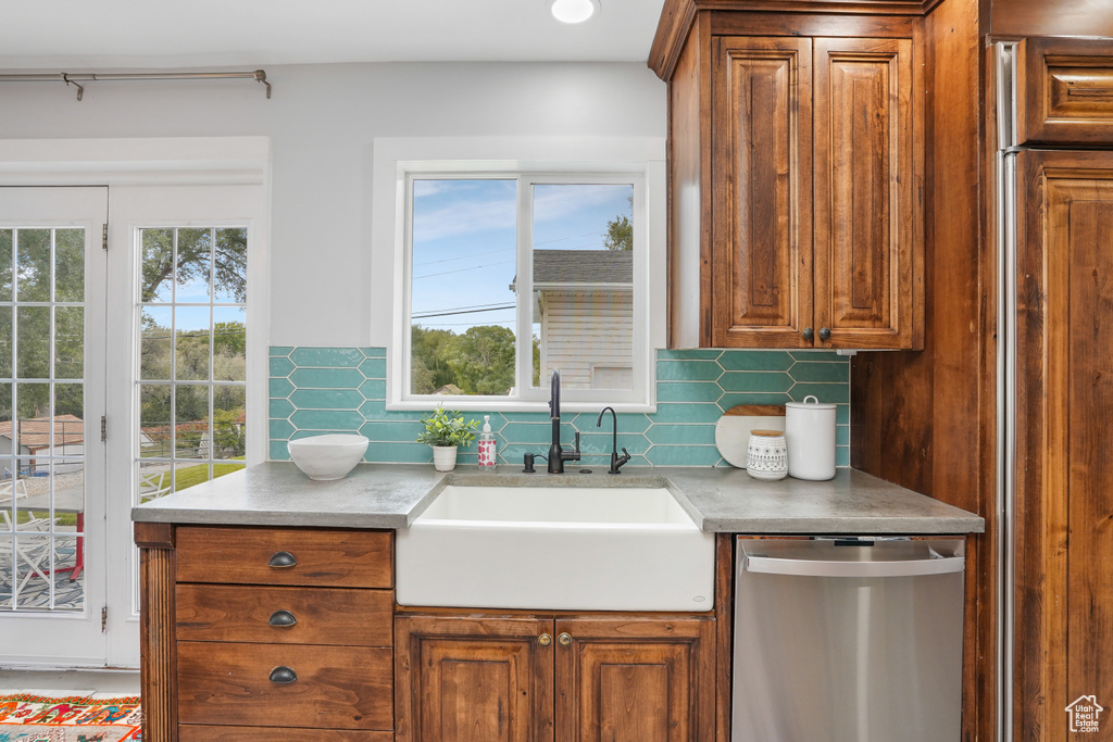 Kitchen with sink, plenty of natural light, stainless steel dishwasher, and tasteful backsplash