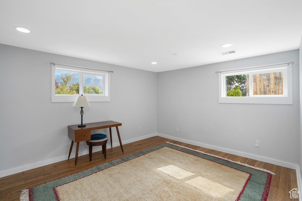 Unfurnished room featuring dark hardwood / wood-style flooring and a wealth of natural light