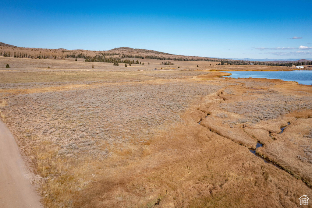 Property view of mountains with a rural view and a water view