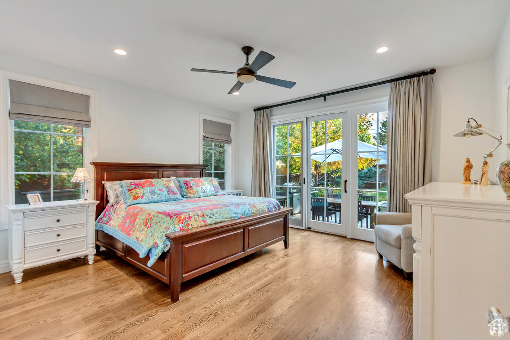 Bedroom featuring light wood-type flooring, multiple windows, ceiling fan, and access to outside