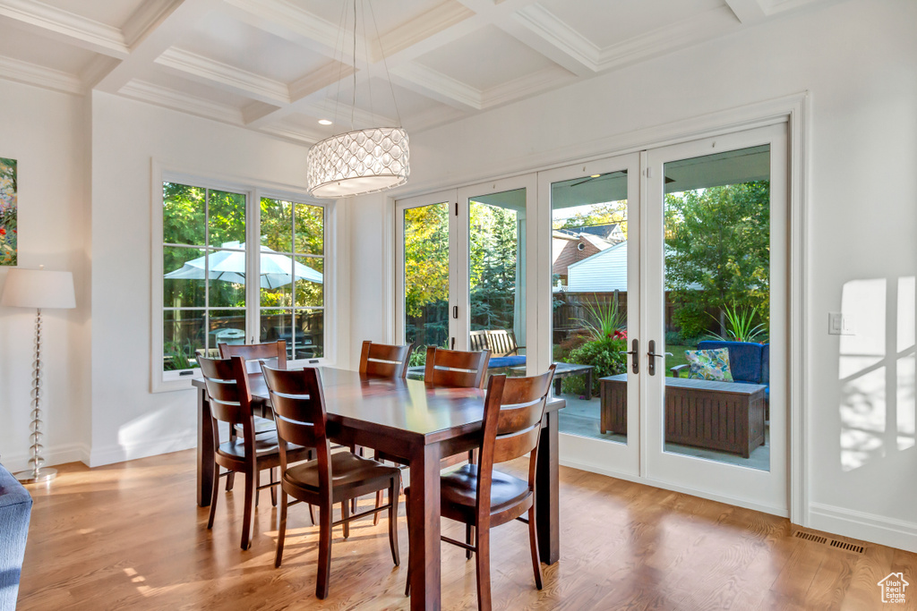 Dining area with light wood-type flooring, beamed ceiling, a wealth of natural light, and french doors