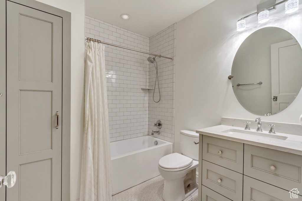 Full bathroom featuring tile patterned floors, vanity, toilet, and shower / bathtub combination with curtain