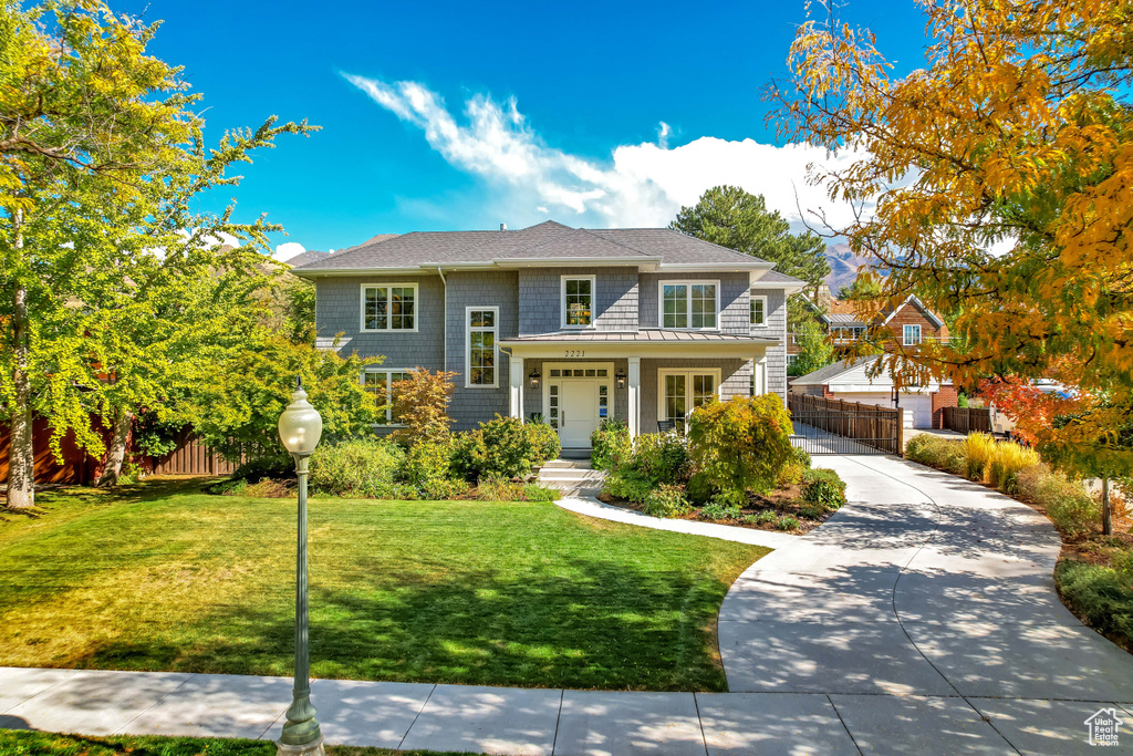 View of front of home featuring covered porch and a front yard