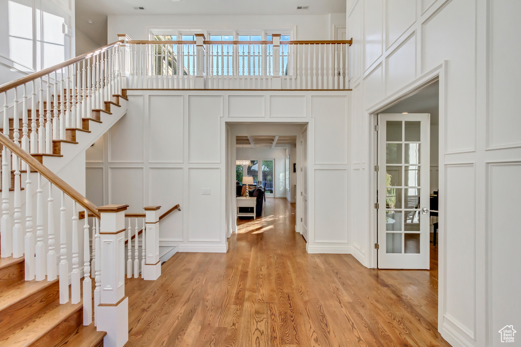 Entryway with a high ceiling and light hardwood / wood-style flooring