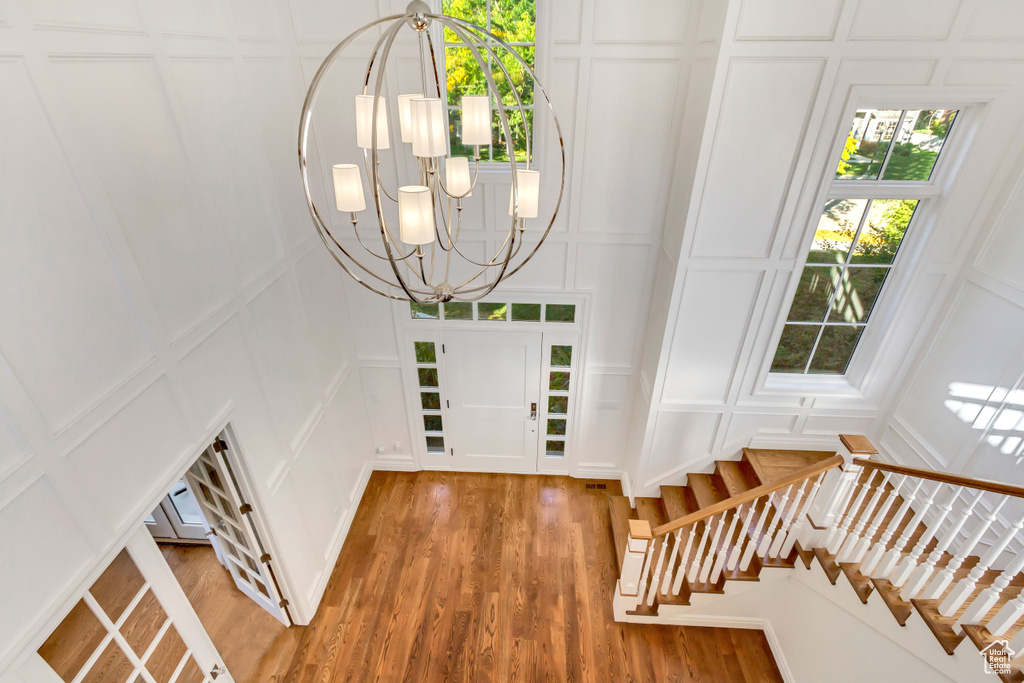 Entrance foyer with hardwood / wood-style flooring and a chandelier