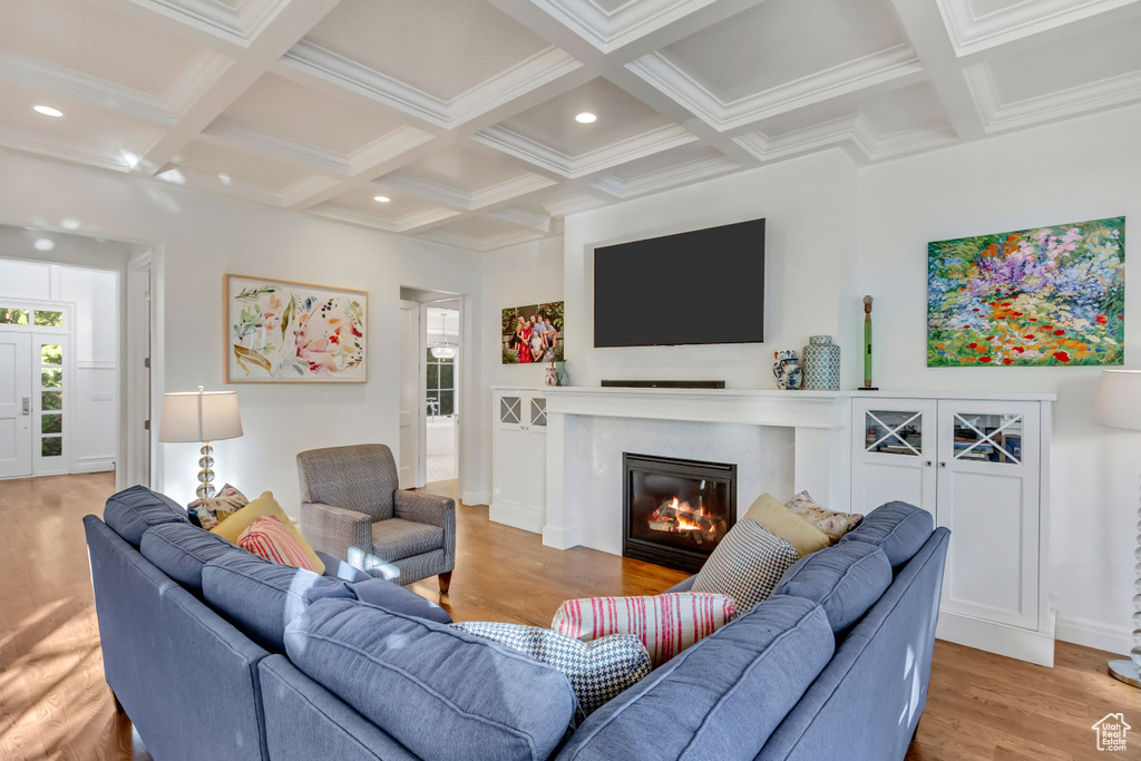 Living room with plenty of natural light, beam ceiling, and light wood-type flooring