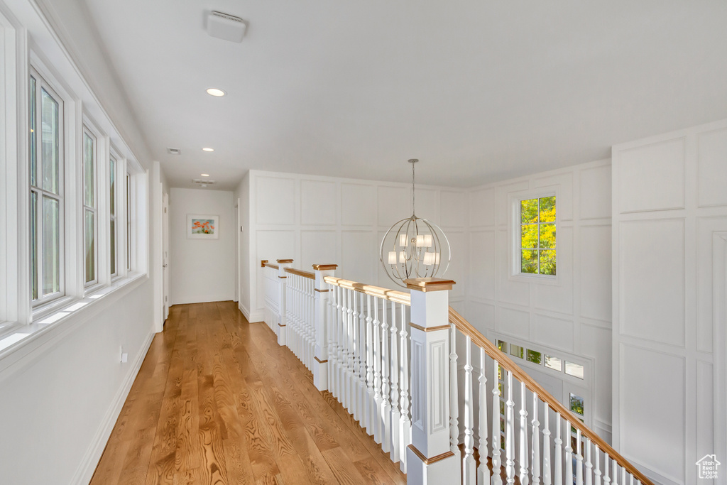 Hall featuring an inviting chandelier and light wood-type flooring