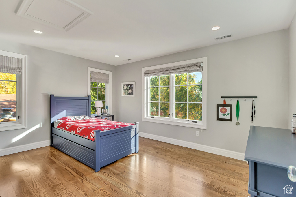 Bedroom featuring multiple windows and light hardwood / wood-style flooring