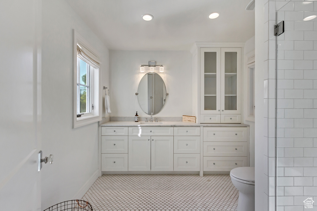 Bathroom with vanity, toilet, and tile patterned floors