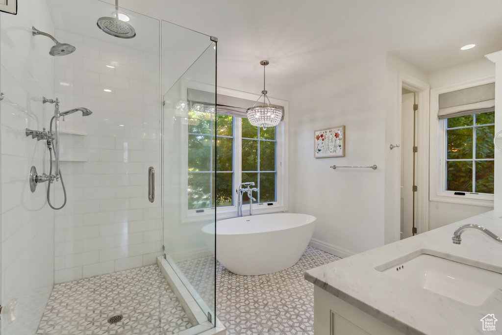 Bathroom featuring tile patterned floors, vanity, a chandelier, and shower with separate bathtub