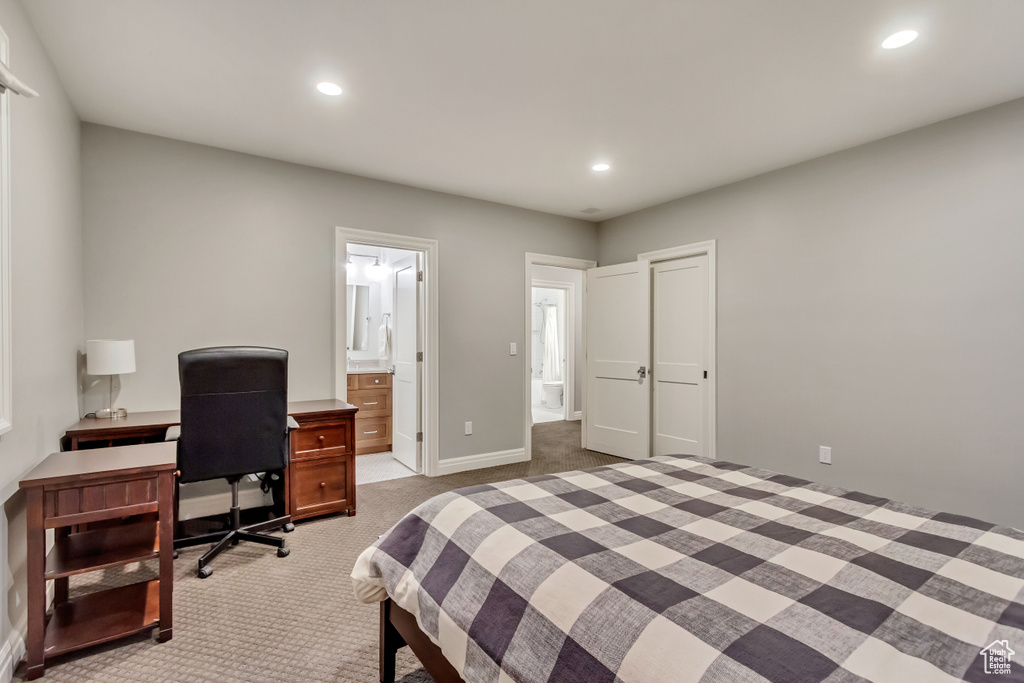 Bedroom featuring a closet, connected bathroom, and light carpet