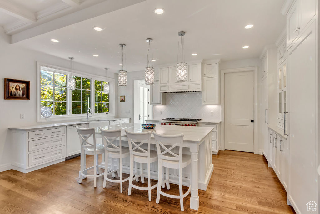 Kitchen featuring pendant lighting, light hardwood / wood-style flooring, and a kitchen island