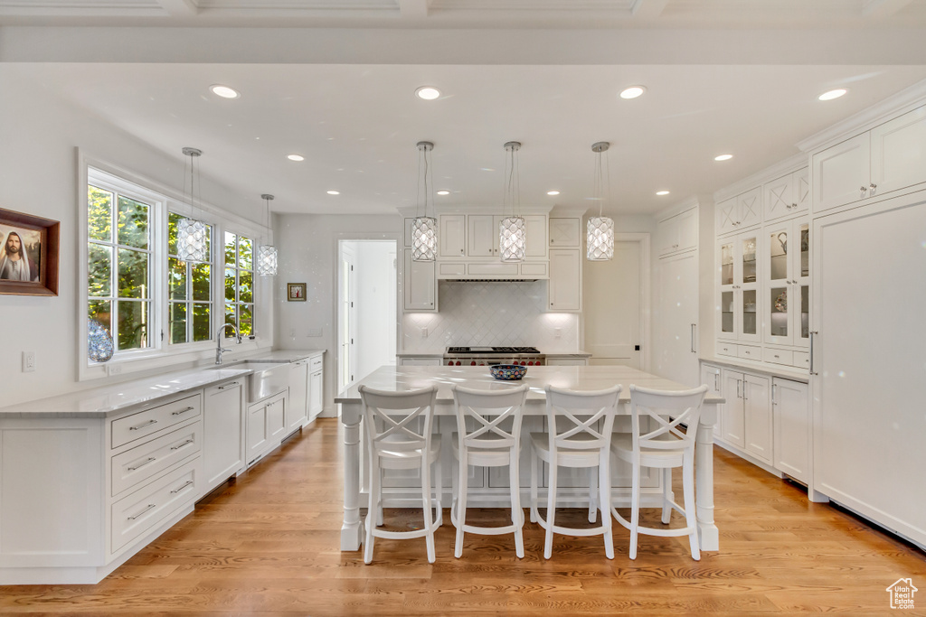 Kitchen featuring white cabinetry, a center island, and decorative light fixtures