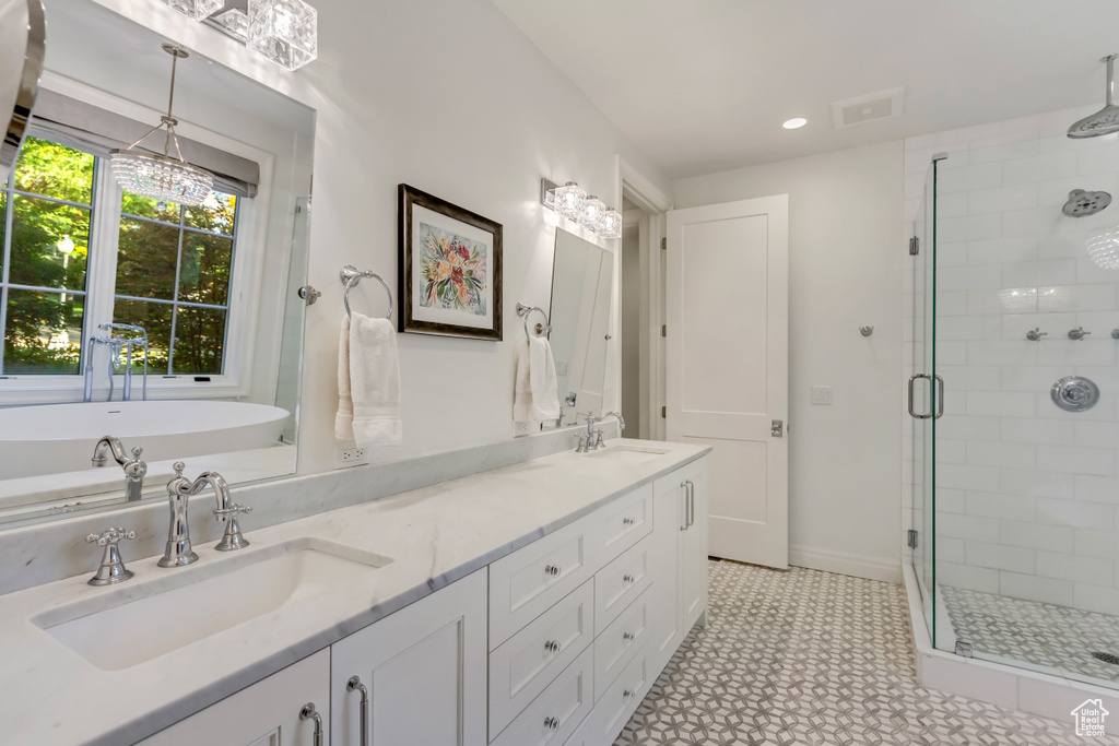 Bathroom featuring shower with separate bathtub and vanity