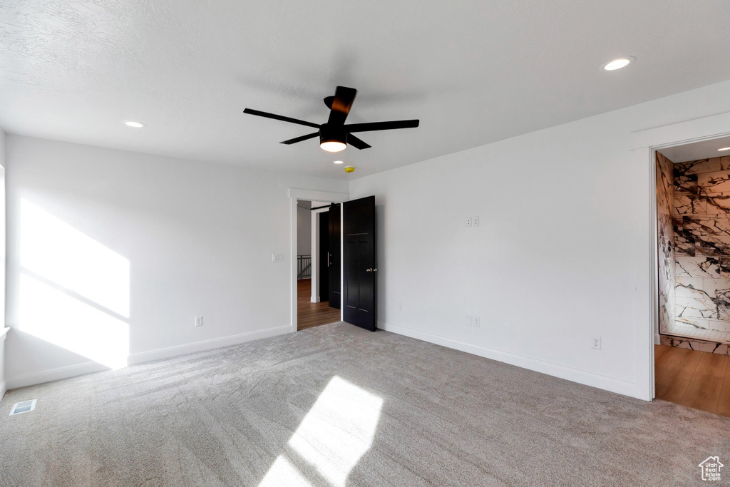 Spare room with ceiling fan and light colored carpet