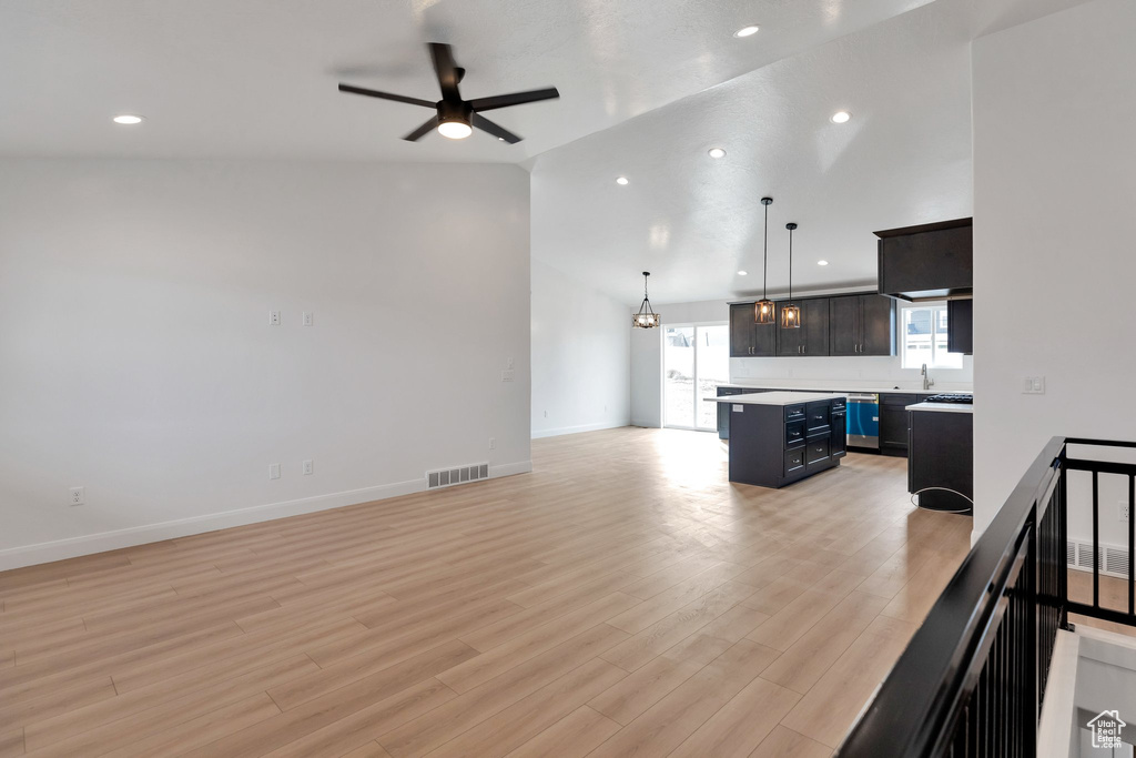 Living room with ceiling fan, light wood-type flooring, sink, and high vaulted ceiling